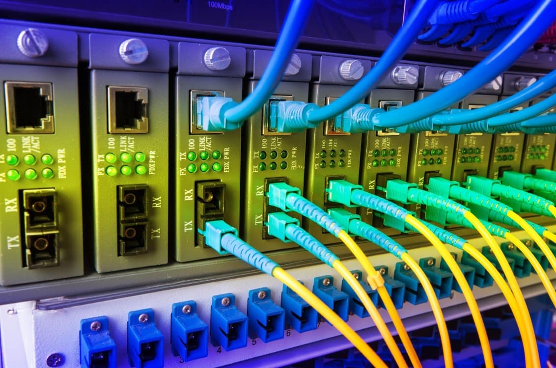 Fiber optic media converters and patch cables on a rack-mounted panel